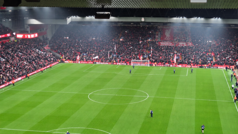 Wide-angle photograph of Anfield showing the pitch and packed stands, with the headline ‘Araújo’s defensive impact’ in white text across the top.